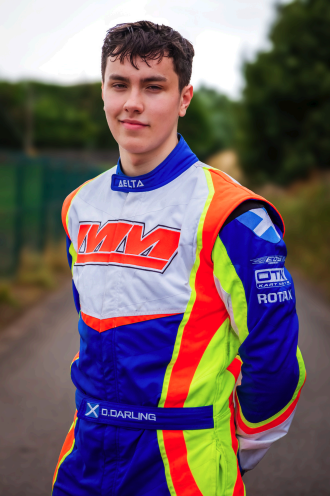 Dominic Darling standing in race suit